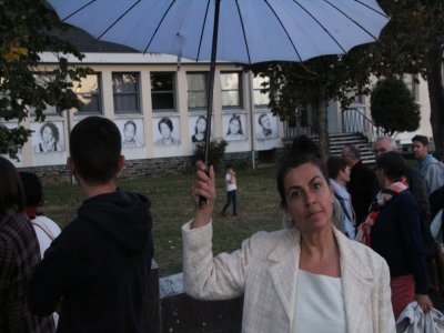 Avec son parapluie, la comédienne du groupe artistique Alice a emmené le public à la découverte des Portraits de rue affichés sur les façades pour l'occasion. - Quentin Hernandez